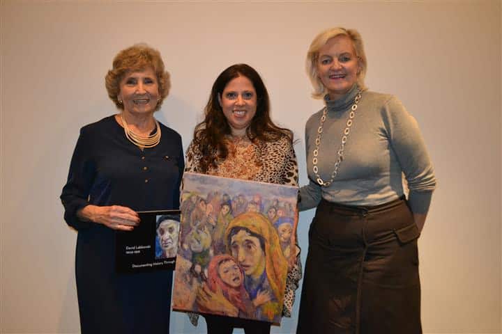 Project manager of DHC, Maureen Caminsky, Leora Raikin, and director of DHC, Mary Kluk, display one of David Labkovski’s paintings.